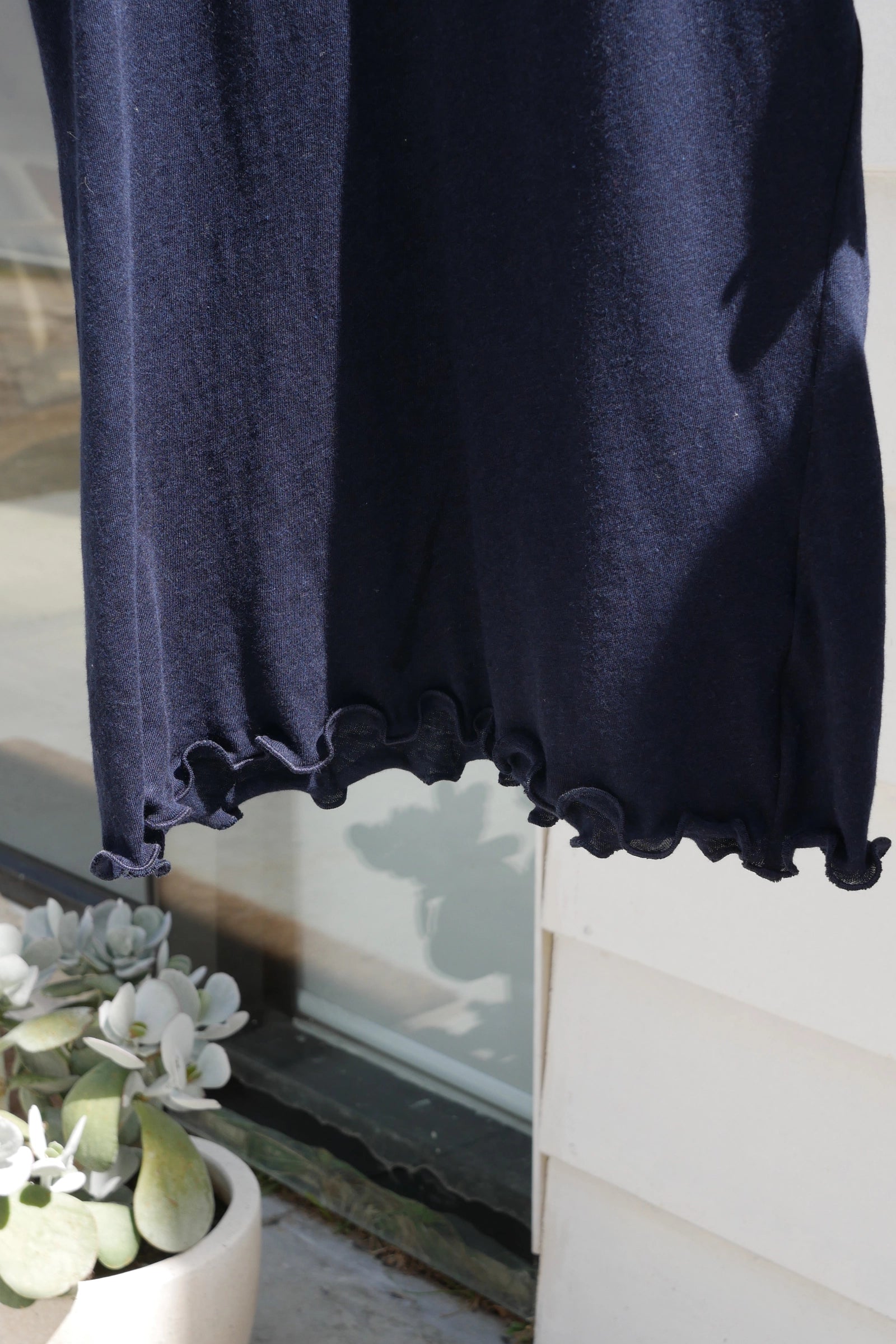 Navy blue tshirt ruffled hem detail  on a white background