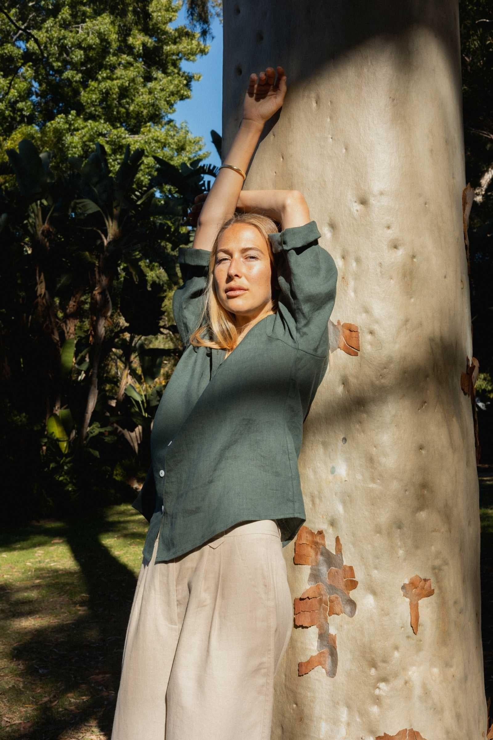 Woman leaning against a tree in a natural setting