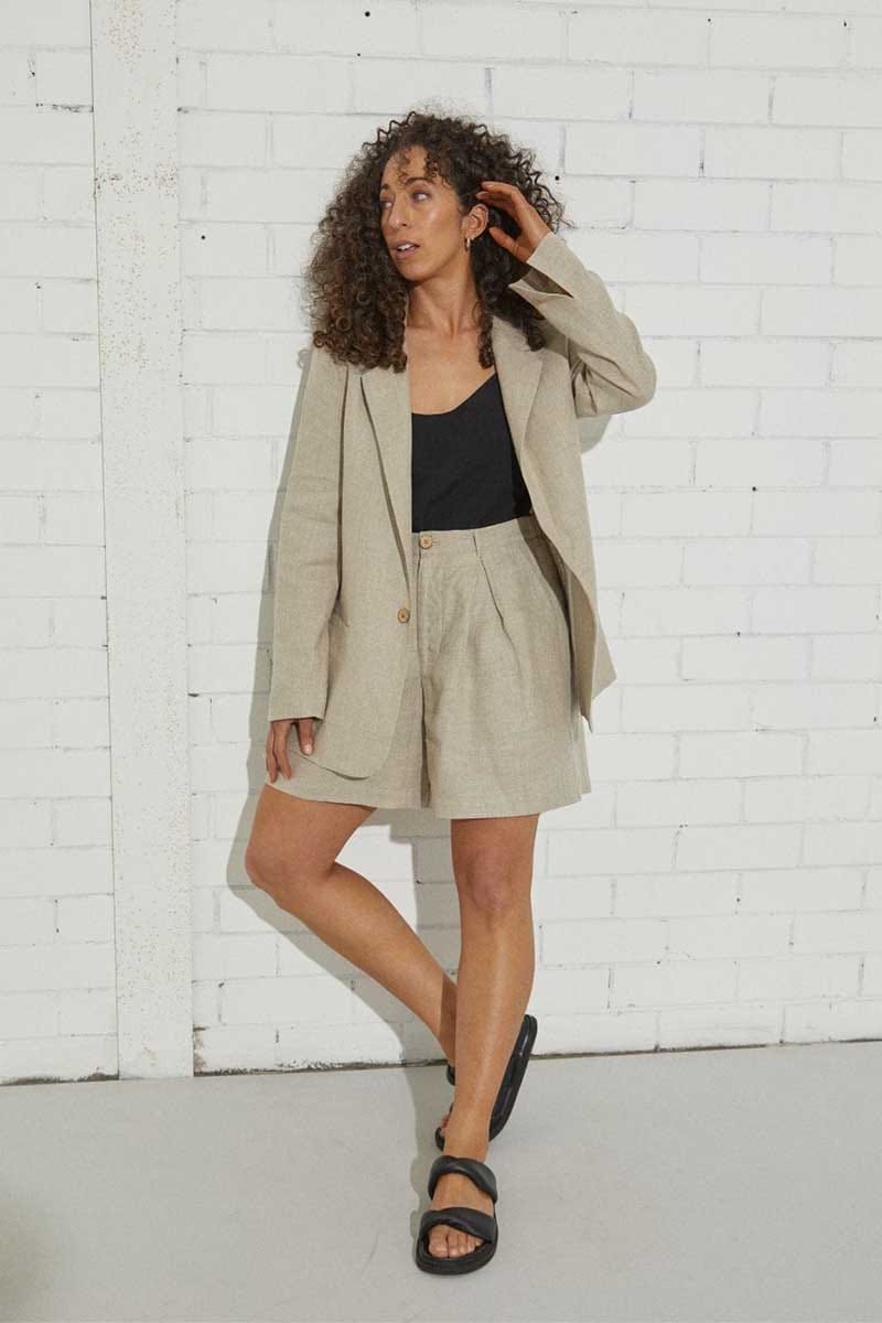 kristin magrit sailor shorts are not too short, but are nice and light and flowy with a deep front pleat, colour natural organic hemp, Buttons made from sustainable coconut shell, model standing in studio