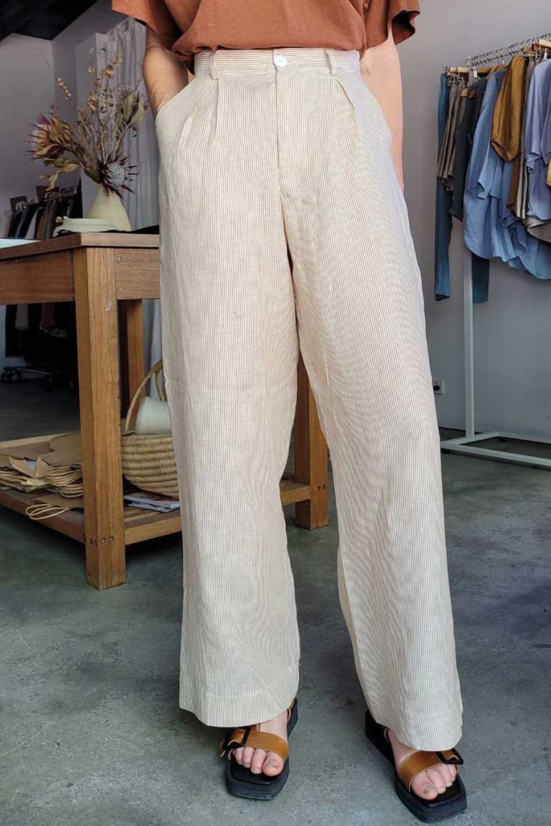 kristin magrit striped sailor pant colour white stripe linen, A long chic leg line with a flattering wide leg cut, Buttons made from sustainable white River Shell, model standing in studio