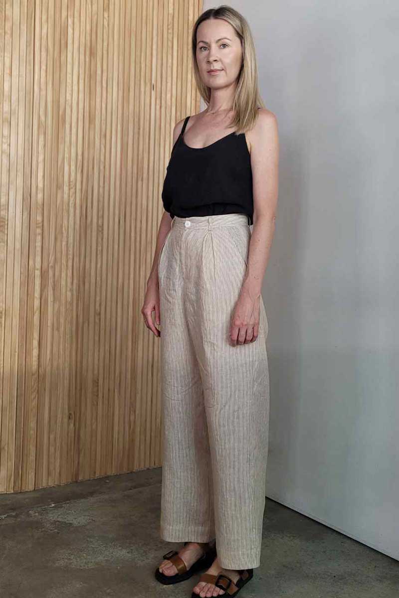 kristin magrit striped sailor pant colour white stripe linen, A long chic leg line with a flattering wide leg cut, Buttons made from sustainable white River Shell, model standing in studio black top