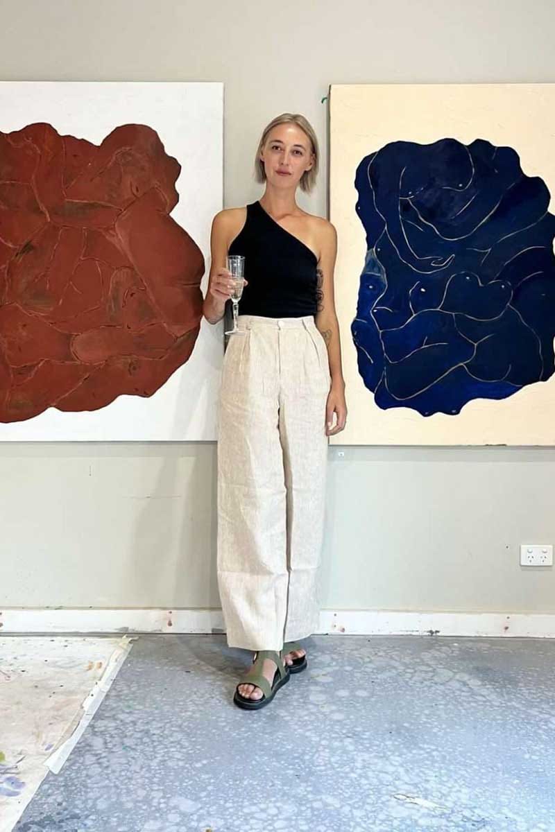 kristin magrit striped sailor pant colour white stripe linen, A long chic leg line with a flattering wide leg cut, Buttons made from sustainable white River Shell, model standing in front of art