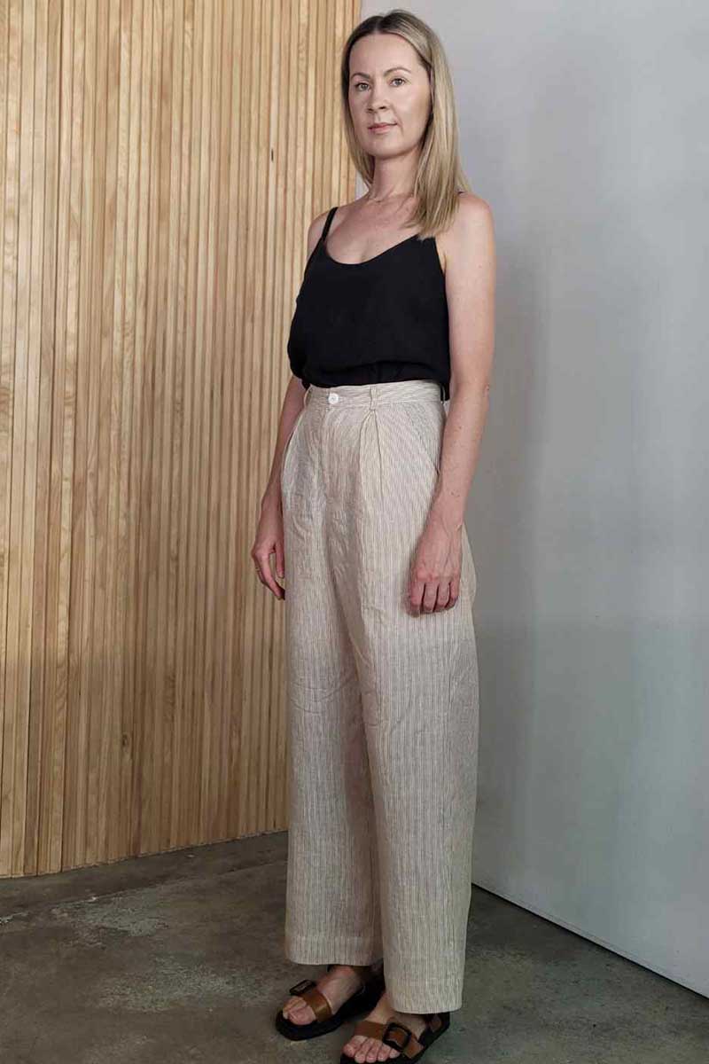 kristin magrit striped sailor pant colour white stripe linen, A long chic leg line with a flattering wide leg cut, Buttons made from sustainable white River Shell, model standing in studio  black top
